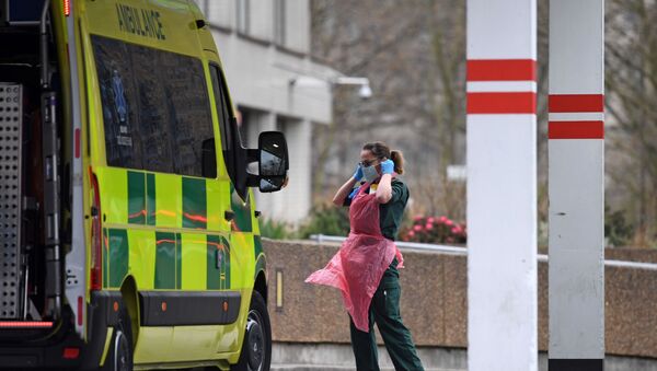 A member of staff wearing PPE of gloves, an apron and a face mask as a precautionary measure against COVID-19, prepares to disinfect an ambulance after it arrived with a patient at St Thomas' Hospital in north London, on April 1, 2020, as life in Britain continues during the nationwide lockdown to combat the novel coronavirus pandemic.  - Sputnik International