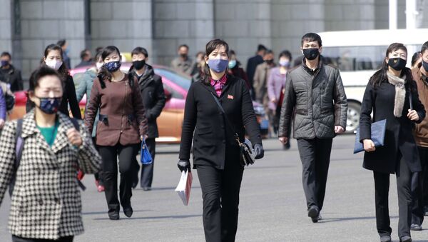 Pedestrians wear face masks to help prevent the spread of the coronavirus, Wednesday, 1 April 2020, in Pyongyang, North Korea.  - Sputnik International
