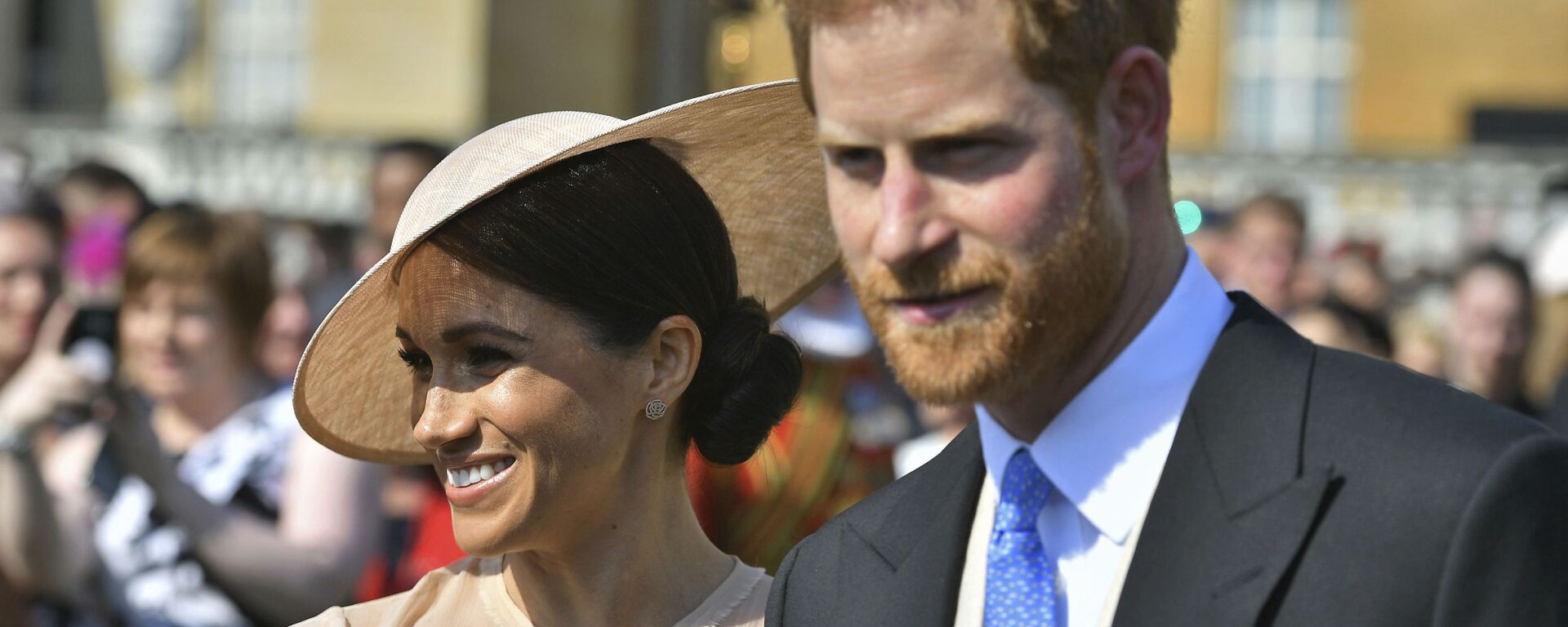 Meghan, the Duchess of Sussex walks with her husband, Prince Harry as they attend a garden party at Buckingham Palace in London, 22 May 2018 - Sputnik International, 1920, 16.07.2020