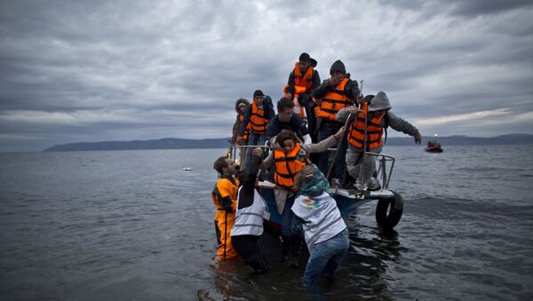 In this Thursday, Dec. 3, 2015 photo, volunteers help refugees disembark from a vessel carrying Yazidi refugee Samir Qasu, 45, from Sinjar, Iraq, and his wife Bessi, 42, their two daughters Delphine, 18, seen center left,  Dunia 13, and their two sons Dilshad, 17, seen center left, and Dildar, 10, as it arrives to the northeastern Greek island of Lesbos from the Turkish coast. - Sputnik International