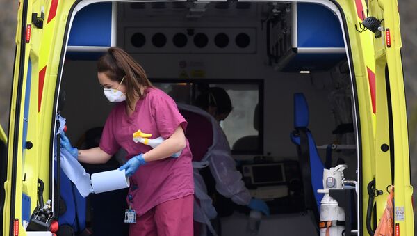 Staff wearing PPE of gloves and face masks, as a preactionary measure against COVID-19, disinfect an ambulance after it arrived with a patient at St Thomas' Hospital in north London, on April 1, 2020,  - Sputnik International