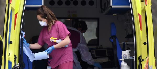 Staff wearing PPE of gloves and face masks, as a preactionary measure against COVID-19, disinfect an ambulance after it arrived with a patient at St Thomas' Hospital in north London, on April 1, 2020,  - Sputnik International