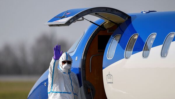 A medical staff waves as a patient from France is transferred from an ambulance aircraft to an ambulance car at the airport in Dresden, as the spread of the coronavirus disease (COVID-19) continues in Dresden, Germany April 2, 2020.  - Sputnik International