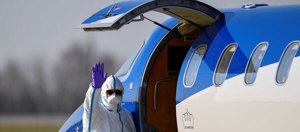 A medical staff waves as a patient from France is transferred from an ambulance aircraft to an ambulance car at the airport in Dresden, as the spread of the coronavirus disease (COVID-19) continues in Dresden, Germany April 2, 2020.  - Sputnik International
