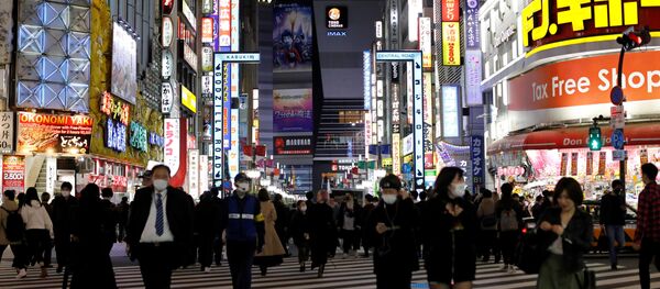 Passersby wearing protective face masks, following an outbreak of the coronavirus disease (COVID-19), walk at Kabukicho entertainment and shopping district in Tokyo, Japan, 27 March 2020 - Sputnik International