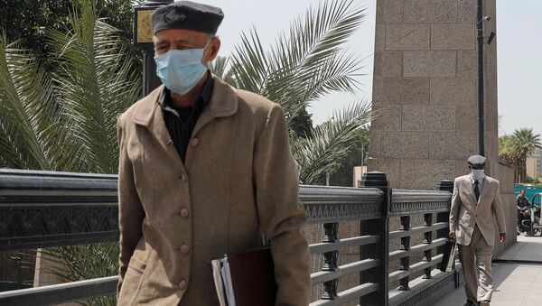 Older men wearing protective masks amid concerns over the coronavirus disease (COVID-19) walk on the Qasr el-Nil Bridge across the Nile river in Egyptian capital Cairo, Egypt March 31, 2020.  - Sputnik International