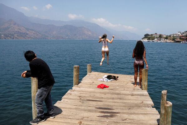 Backpacker and Spanish language student Lola Daehler, from the U.S., jumps into the water after she decided to stay in Guatemala, where she feels safer to confront the outbreak of coronavirus disease (COVID-19), in San Pedro La Laguna, Solola, Guatemala March 27, 2020 - Sputnik International