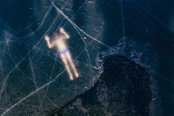 Aerial view shows Finland's freediver Kristian Maki-Jussila, 37, swimming under the ice of a frozen lake on March 28, 2020 near Vaasa, Finland - Sputnik International