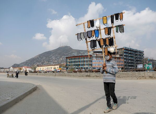 An Afghan boy holds protective face masks for sale in downtown, during the coronavirus disease (COVID-19) outbreak in Kabul, Afghanistan March 29, 2020 - Sputnik International