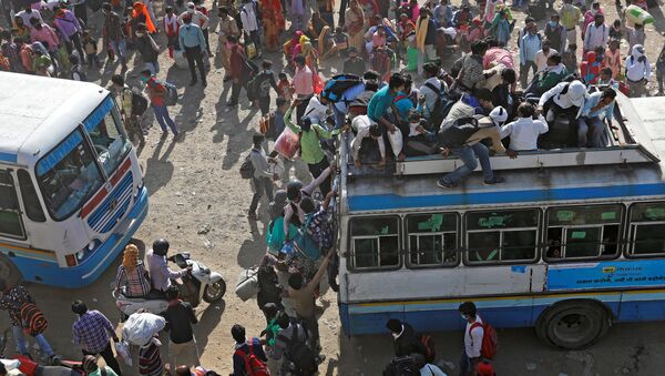 Migrant workers travel on crowded buses as they return to their villages, during a 21-day nationwide lockdown to limit the spreading of coronavirus disease (COVID-19), in Ghaziabad, on the outskirts of New Delhi, India, March 29, 2020 - Sputnik International