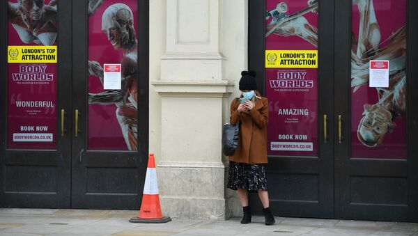  A woman looks at her phone whilst wearing a mask in Shaftesbury Avenue as the spread of the coronavirus disease (COVID-19) continues, London, Britain, March 31, 2020 - Sputnik International