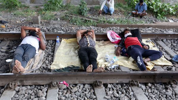 Migrant workers rest on a railway track during a 21-day nationwide lockdown to slow the spreading of coronavirus disease (COVID-19) in in Mumbai, India, 2 April 2020 - Sputnik International