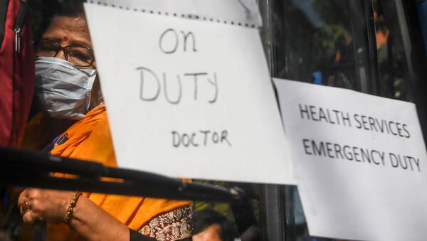 Governmental doctors board a bus to go to several districts as reinforcement in the city during a government-imposed nationwide lockdown as a preventive measure against the COVID-19 coronavirus, in Kolkata on March 27, 2020.  - Sputnik International