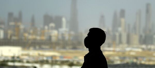 A man wearing a protective mask stands at a racetrack overlooking Dubai following the UAE's decision to postpone the upcoming Dubai Horse Racing amid the COVID-19 coronavirus pandemic, on March 23, 2020 in Dubai A man wearing a protective mask stands at a racetrack overlooking Dubai following the UAE's decision to postpone the upcoming Dubai Horse Racing amid the COVID-19 coronavirus pandemic, on March 23, 2020 in Dubai - Sputnik International