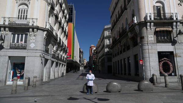 A pharmacist in protective gear stands in a deserted Puerta del Sol square - Sputnik International