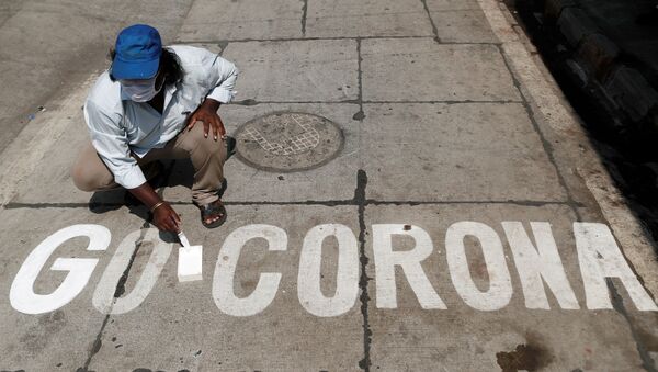 A man paints a message on a street after India ordered a 21- day nationwide lockdown to limit the spreading of coronavirus disease (COVID-19) in Mumbai, India March 28, 2020.  - Sputnik International