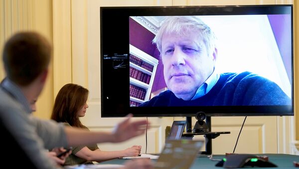 Britain's Prime Minister Boris Johnson appears on a monitor for the coronavirus disease (COVID-19) meeting in London, Britain March 28, 2020 - Sputnik International