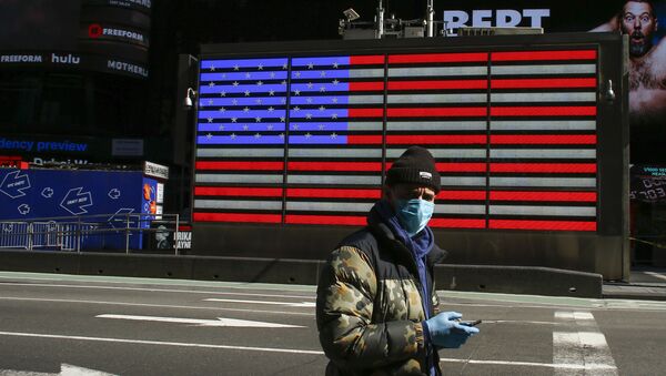 A man wears a face mask as he checks his phone in Times Square on March 22, 2020 in New York City. - Coronavirus deaths soared across the United States and Europe on despite heightened restrictions as hospitals scrambled to find ventilators - Sputnik International