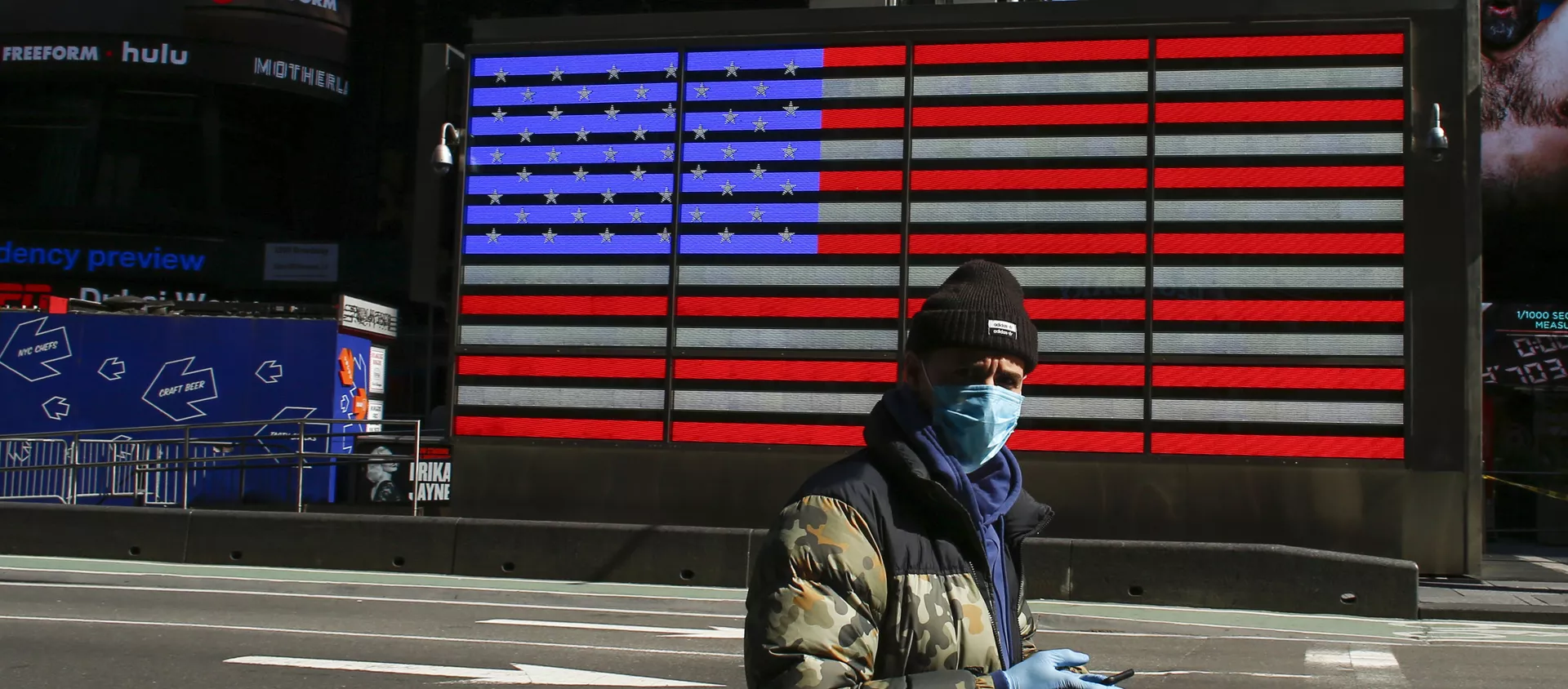 A man wears a face mask as he checks his phone in Times Square on March 22, 2020 in New York City. - Coronavirus deaths soared across the United States and Europe on despite heightened restrictions as hospitals scrambled to find ventilators - Sputnik International, 1920, 06.04.2020