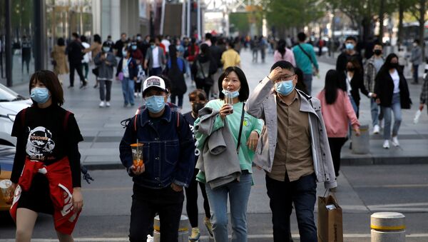 People wearing face masks are seen at a shopping area in Beijing, as the spread of the novel coronavirus disease (COVID-19) continues in China, 6 April 2020.  - Sputnik International