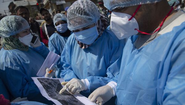 Kashmiri doctors and health workers identify the area to be monitored on an aerial map during a contact-tracing drive after the first person in the region was tested positive for COVID-19 in Srinagar, Indian controlled Kashmir, Thursday, March 19, 2020 - Sputnik International