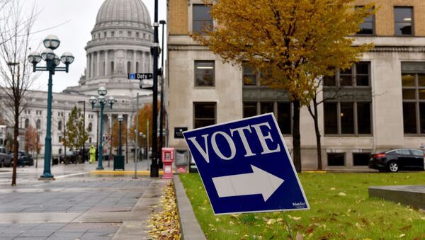 A sign directs voters towards a polling place near the state capitol in Madison, Wisconsin, U.S. November 6, 2018 - Sputnik International