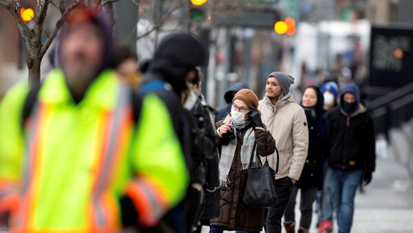 FILE PHOTO: A woman adjusts her mask while she waits in line as the city's public health unit holds a walk-in clinic testing for coronavirus disease (COVID-19) in Montreal, Quebec, Canada March 23, 2020.  REUTERS/Christinne Muschi/File Photo - Sputnik International