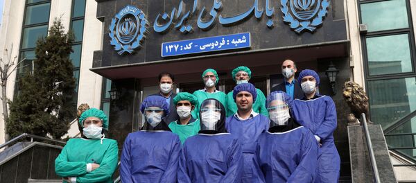 Bank employees wear protective face masks, following the outbreak of coronavirus, as they pose for a photo in Tehran, Iran March 17, 2020.  - Sputnik International