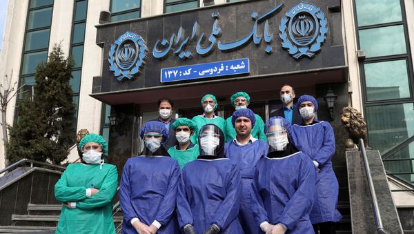 Bank employees wear protective face masks, following the outbreak of coronavirus, as they pose for a photo in Tehran, Iran March 17, 2020.  - Sputnik International