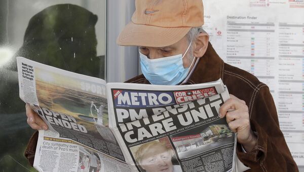 A man reads a newspaper with the headline: 'PM in intensive care', outside St Thomas' Hospital in central London as British Prime Minister Boris Johnson is in intensive care fighting the coronavirus in London, Tuesday, April 7, 2020.  - Sputnik International