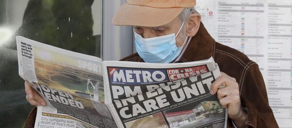 A man reads a newspaper with the headline: 'PM in intensive care', outside St Thomas' Hospital in central London as British Prime Minister Boris Johnson is in intensive care fighting the coronavirus in London, Tuesday, April 7, 2020.  - Sputnik International
