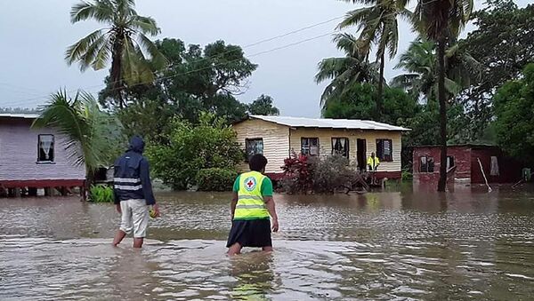 This handout photo taken and received on April 8, 2020 by the International Federation of Red Cross (IFRC) Pacific shows rescue workers making their way through a village during flooding caused by the Tropical Cyclone Harold in Nasolo in Fiji. - A deadly Pacific storm slammed into Fiji on April 8, tearing off roofs and flooding towns, after leaving a trail of destruction in the Solomon Islands and Vanuatu.  - Sputnik International