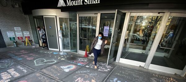 A woman exits Mount Sinai Hospital in Manhattan past messages of thanks written on the sidewalk during the outbreak of the coronavirus disease (COVID19) in New York City, New York, U.S., April 7, 2020.  - Sputnik International