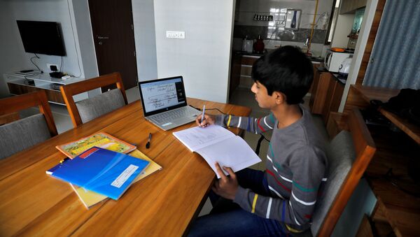 A student makes notes as he attends an online class at his home after Gujarat government ordered the closure of schools and colleges across the state amid coronavirus fears, in Ahmedabad, India, March 17,2020 - Sputnik International
