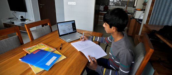A student makes notes as he attends an online class at his home after Gujarat government ordered the closure of schools and colleges across the state amid coronavirus fears, in Ahmedabad, India, March 17,2020 A student makes notes as he attends an online class at his home after Gujarat government ordered the closure of schools and colleges across the state amid coronavirus fears, in Ahmedabad, India, March 17,2020 - Sputnik International