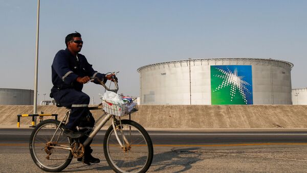 An employee rides a bicycle next to oil tanks at Saudi Aramco oil facility in Abqaiq, Saudi Arabia October 12, 2019.  - Sputnik International