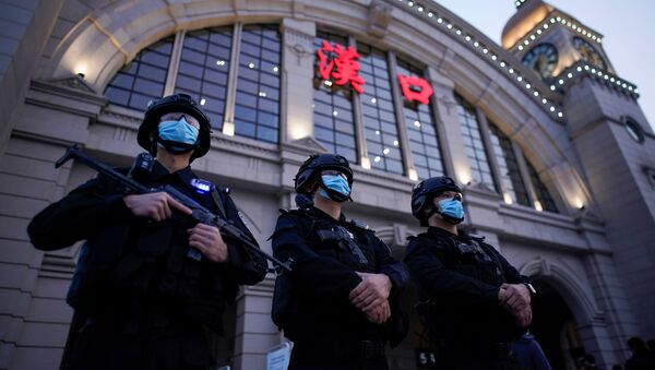 Сотрудники службы безопасности в защитных масках у железнодорожного вокзала Ханькоу в Ухане, Китай - Sputnik International