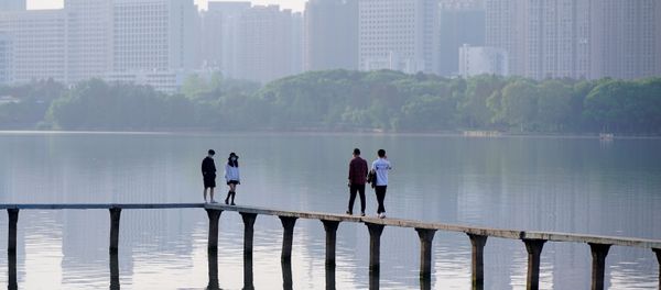 People wearing face masks, walk along the East Lake after lockdown in Wuhan, the epicentre of China's novel coronavirus disease (COVID-19) outbreak, is lifted, in Wuhan, Hubei province, China, April 9, 2020 - Sputnik International