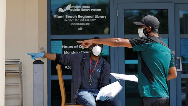 A man speaks with a library worker after receiving an unemployment form, as the outbreak of coronavirus disease (COVID-19) continues, in Miami Beach, Florida, U.S., April 8, 2020 - Sputnik International