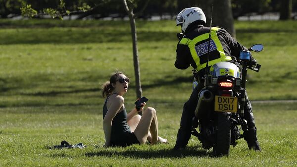 A woman is told to go home by a police officer on a motorbike to stop the spread of coronavirus and keep the park open for people observing the British government's guidance of social distancing, only using parks for dog walking, one form of exercise a day, like a run, walk, or cycle alone or with members of the same household, on Primrose Hill in London, Sunday, April 5, 2020.  - Sputnik International