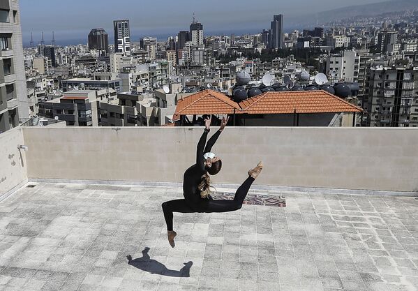 Sherazade Mami, a 28-year-old Tunisian professional dancer and performer at the Caracalla dance theatre and a teacher at the Caracalla dance school, practices while wearing a surgical mask on the roof of her apartment building in the suburb of Dekwaneh on the eastern outskirts of Lebanon's capital Beirut on April 4, 2020. - Sputnik International