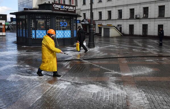 Worker disinfects sidewalks near the Komsomolskaya metro station in Moscow. - Sputnik International