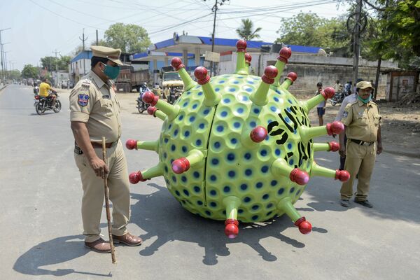 Police officers patrol streets as inventor Sudhakar Yadav (inside) leads his coronavirus-themed made car on a road for an awareness campaign during a government-imposed nationwide lockdown as a preventive measure against the COVID-19 coronavirus, in Hyderabad on April 8, 2020.  - Sputnik International