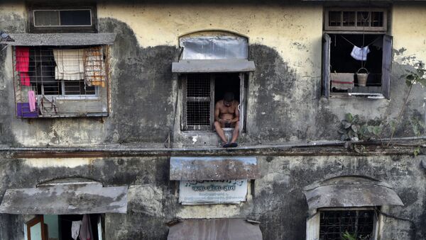 A man sits alone at the window of a Chawl during a lockdown to prevent the spread of the new coronavirus at Lower Parel area in Mumbai, India, Sunday, April 5, 2020.  - Sputnik International