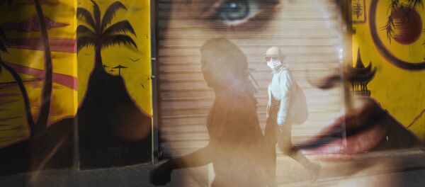 A woman is reflected on a bus station as she wears a protective face mask amid concerns over the country's coronavirus outbreak, in Tel Aviv, Israel, Monday, April 6, 2020.  - Sputnik International