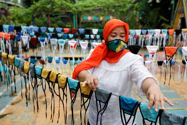 A woman puts cloth face masks on a string to dry before distributing it for free around the neighbourhood, amid the spread of coronavirus disease (COVID-19) outbreak, in Tangerang, on the outskirts of Jakarta, Indonesia, April 9, 2020. - Sputnik International