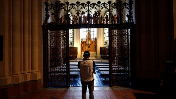 A worker stands outside a chapel set with hospital beds inside the Cathedral Church of St. John the Divine for what will be a temporary field hospital constructed by the Samaritan's Purse and Mount Sinai Hospital on Manhattan's Upper West Side during the outbreak of the coronavirus disease (COVID19) in New York City, New York, U.S., April 8, 2020 - Sputnik International