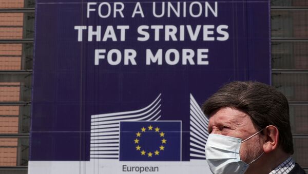 FILE PHOTO: A man wearing a face mask walks past the European Commission headquarters as the spread of coronavirus disease (COVID-19) continues in Brussels, Belgium April 9, 2020.  - Sputnik International