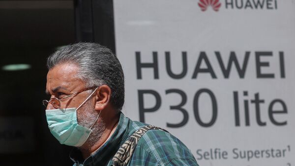 A man, wearing a protective mask due to the spread of coronavirus disease (COVID-19), walks past a Huawei store in Cairo, Egypt March 31, 2020. - Sputnik International