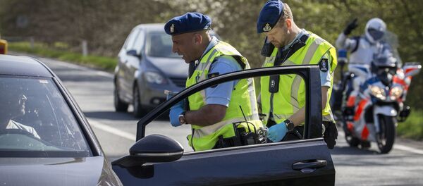 Members of Netherlands' Military police (Marechaussee) speak with drivers and passengers as they carry out additional vehicle checks on the border with Germany at De Rutte on April 10, 2020, as part of attempts to halt the spread of the new coronavirus  - Sputnik International